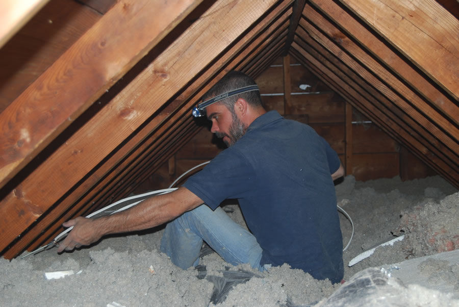 residential electrician working in the attic
